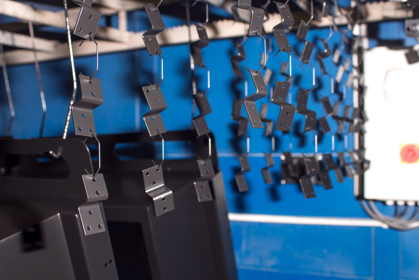 Metal brackets suspended on a coating line